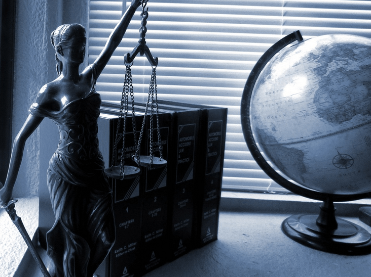Justitia-Figur mit Waage und Gesetzesbüchern – Symbol für Recht, Strategie und steuerfreie Immobilienverkäufe