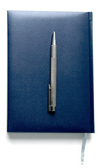 Dunkelblaues Notizbuch mit silbernem Kugelschreiber